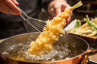 天ぷら職人が銅鍋で揚げる瞬間、衣の泡立ちと黄金色の仕上がり
